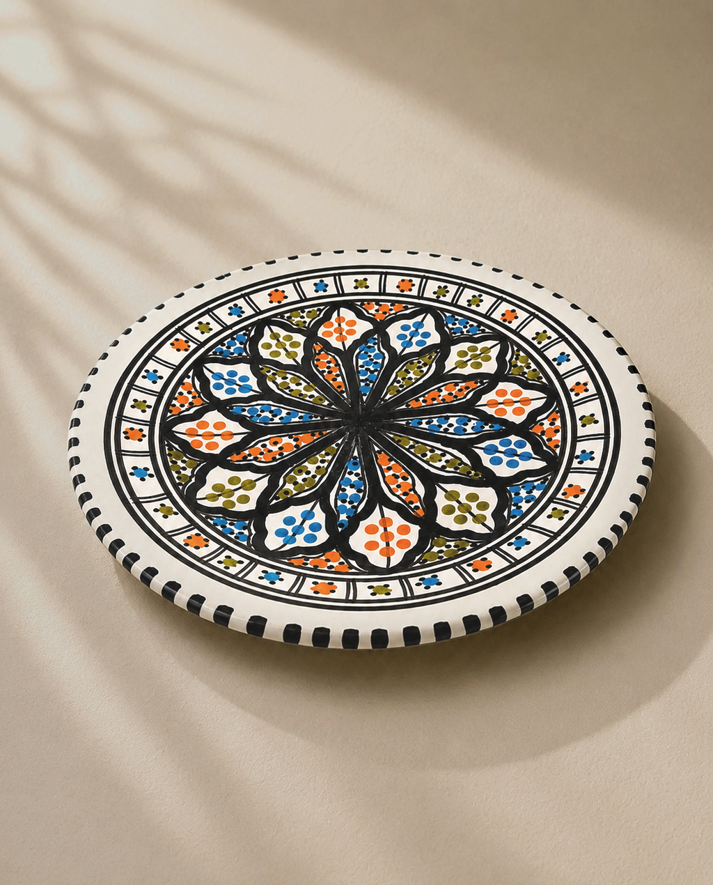 Assiette plate en céramique artisanale tunisienne vue en perspective, collection Djerba.