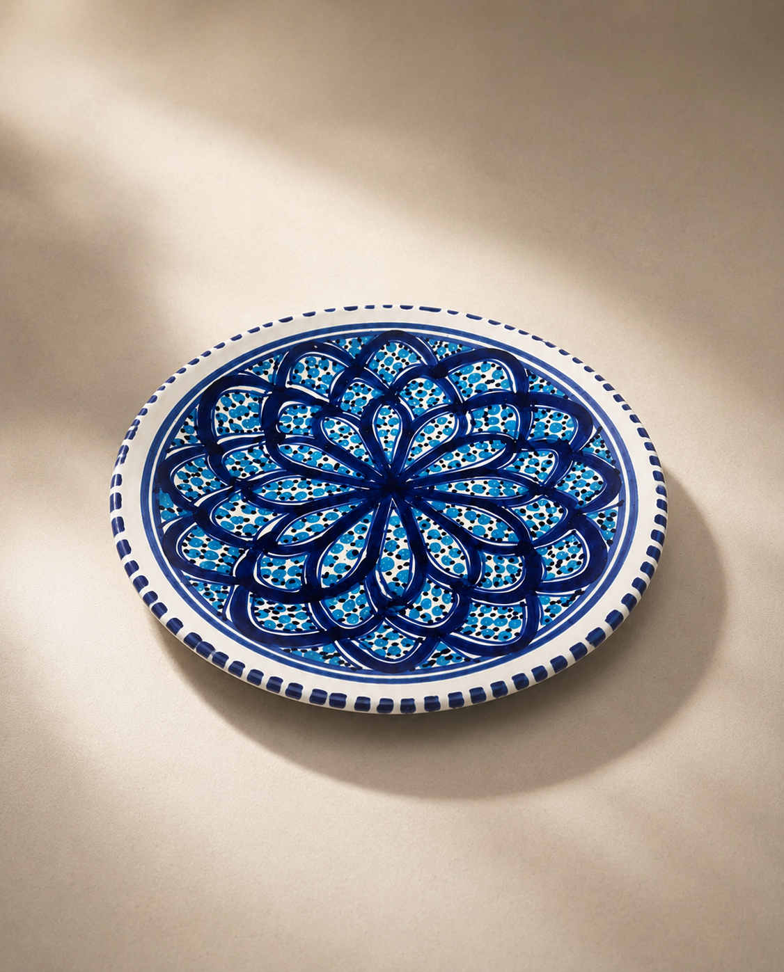 Assiette plate en céramique artisanale tunisienne vue de profil, collection Sidi Bou Saïd.