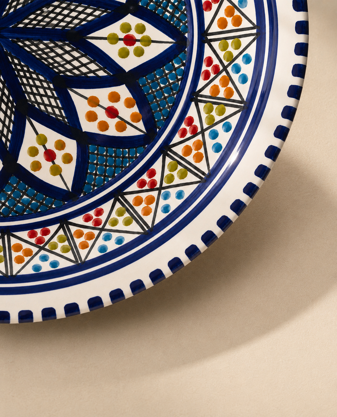 Gros plan sur les motifs d'une assiette creuse en céramique artisanale tunisienne de la collection Médina.