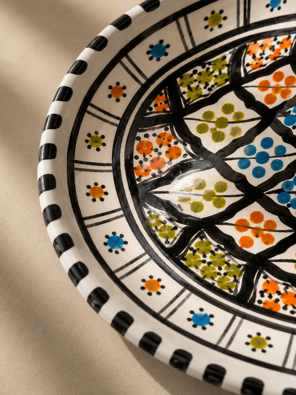 Gros plan du décor peint à la main d'un plat ovale en céramique artisanale de la collection Djerba.