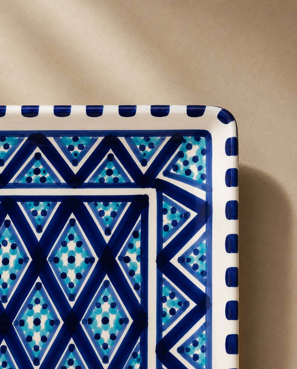 Gros plan sur le décor d'un plat rectangulaire en céramique artisanale tunisienne de la collection Sidi Bou Saïd.