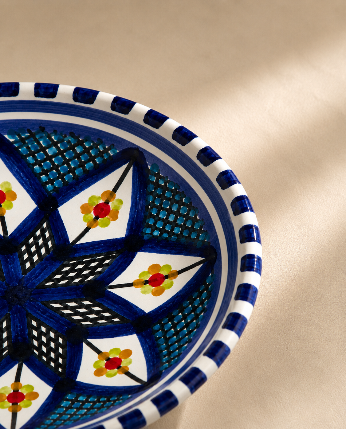 Gros plan sur une petite assiette creuse en céramique artisanale tunisienne de la collection Médina.