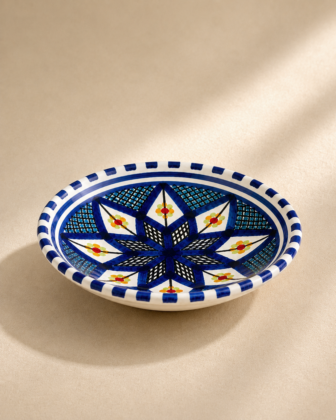 Vue de profil d'une petite assiette creuse en céramique artisanale tunisienne de la collection Médina.