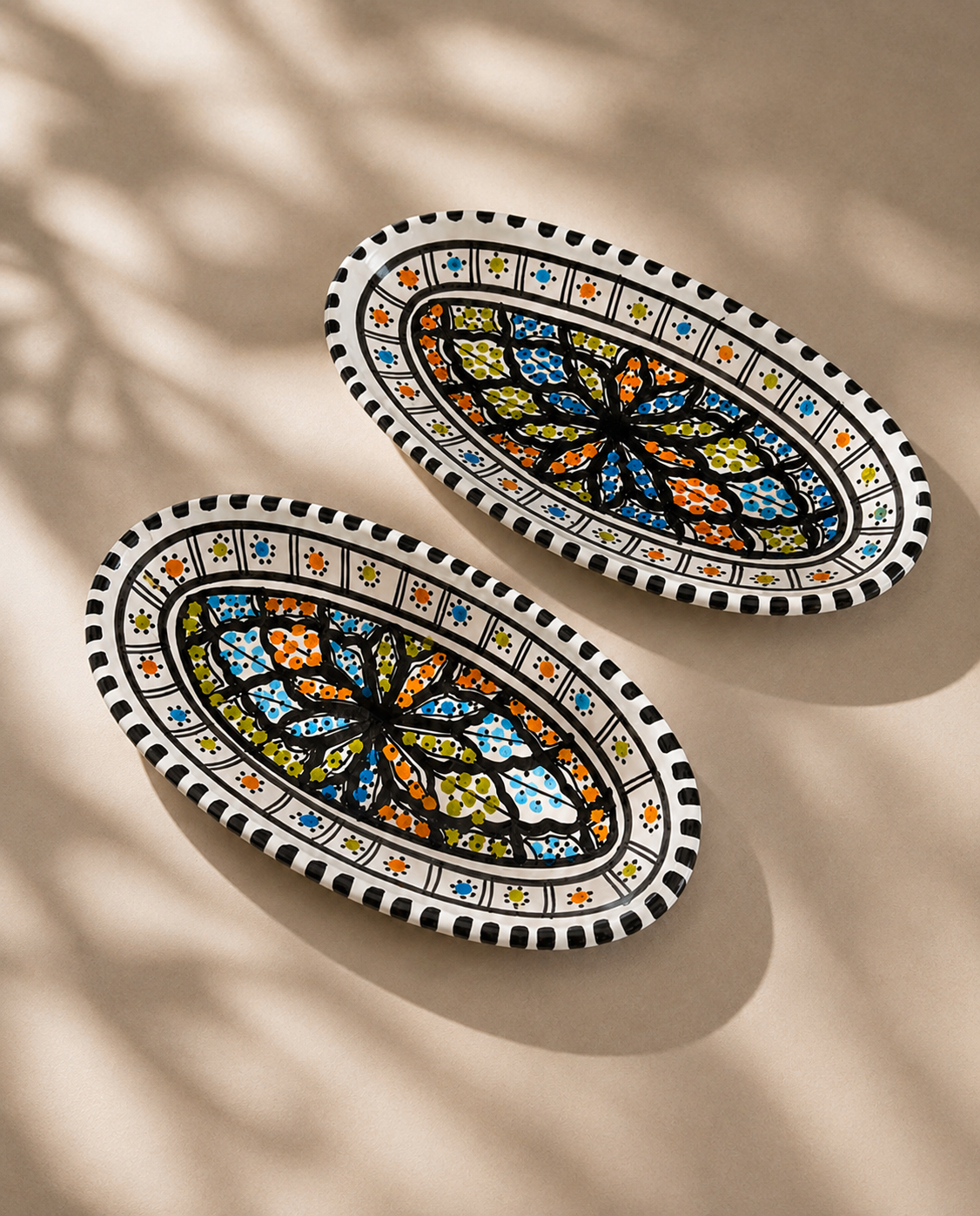 Deux petits plats ovales en céramique artisanale tunisienne vus en perspective, collection Djerba.