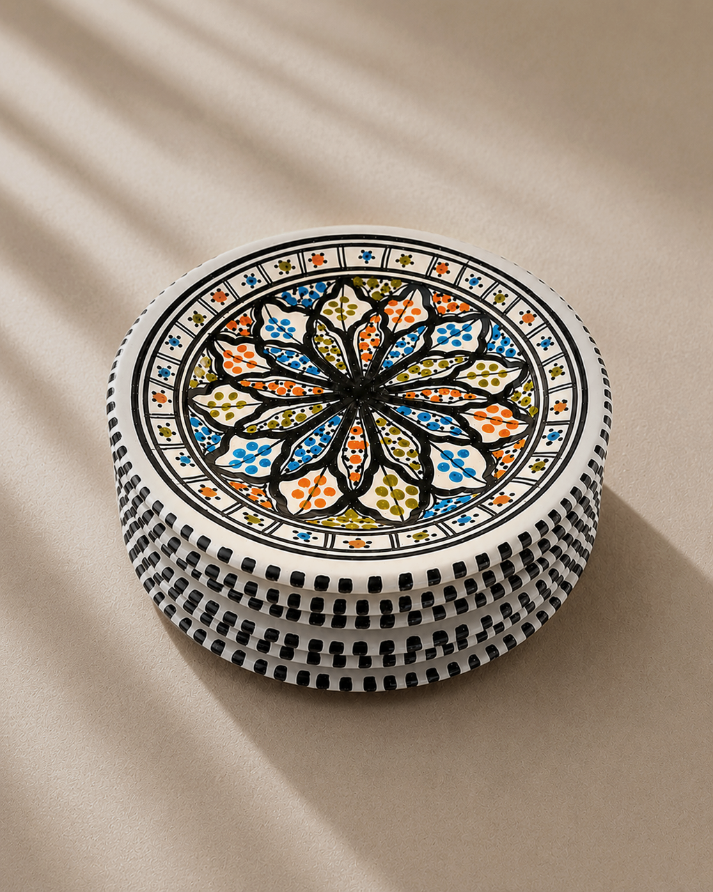 Pile d'assiettes plates en céramique artisanale tunisienne de la collection Djerba.