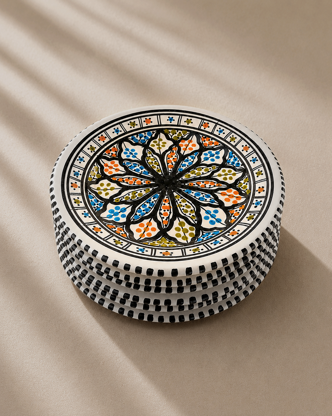 Pile d'assiettes plates en céramique artisanale tunisienne de la collection Djerba.