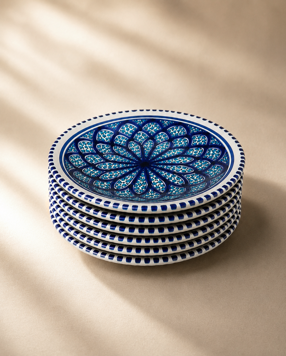 Pile d'assiettes plates en céramique artisanale tunisienne de la collection Sidi Bou Saïd.